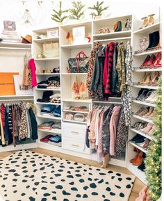 an organized closet with clothes, shoes and handbags on shelve shelves in front of a christmas tree