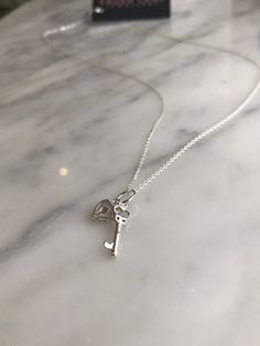 "Sterling silver, mini lock and key charm, measuring 16 x 6mm (key) and 8 x 8 x 2mm (heart lock), hung on diamond cut anchor chain (1mm). *Shown in 20\" length" Silver Charm Necklaces For Valentine's Day With Dangling Charms, Key Locket Necklace, Silver Necklace With Two Keys For Gift, Key Necklace Silver, Lock And Key Necklace, Silver Heart-shaped Locket Necklace With Adjustable Chain, Silver Gothic Charm Necklace With Adjustable Chain, Elegant Sterling Silver Key Necklace, Silver Key Necklace