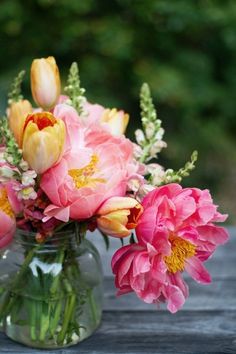 a vase filled with pink and yellow flowers