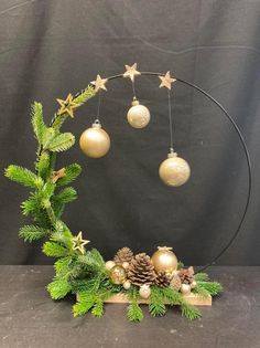 a christmas wreath with ornaments hanging from it's sides and pine cones in the middle