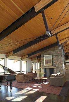 a living room filled with furniture and a piano in the middle of an open floor plan