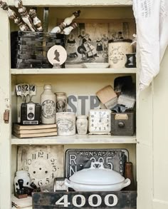 an old fashioned shelf filled with assorted items and decor on top of each other