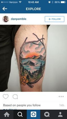 a person with a tattoo on their leg that has a mountain scene in the background