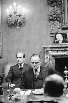 two men in suits sitting at a table