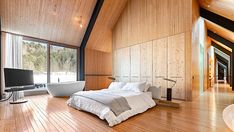 a large bedroom with wooden walls and flooring