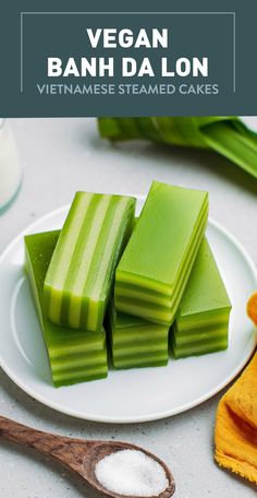 several pieces of celery on a white plate next to a wooden spoon and napkin