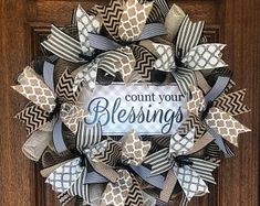 a wreath with the words count your blessing on it in front of a wooden door