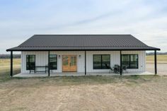 a small white building sitting on top of a dry grass field