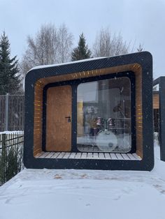 a building made out of wood and glass in the snow