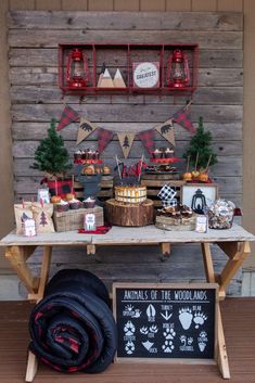 an animal themed birthday party with food and decorations on a wooden table in front of a wood wall