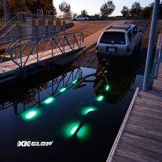 a car is parked on the dock with green lights