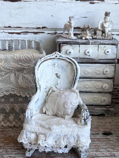 a white chair sitting on top of a wooden floor next to a chest of drawers