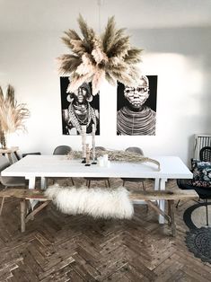 a dining room table with two pictures hanging on the wall behind it and an animal rug in front of it