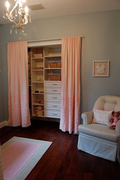 a closet with pink curtains and white furniture