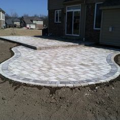 a brick patio in the middle of a yard with no grass or rocks on it