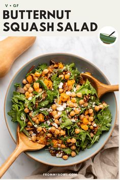 a salad with chickpeas and lettuce in a blue bowl on a white table