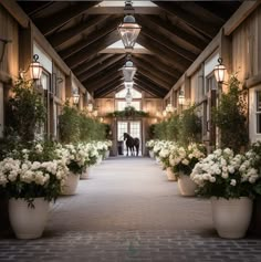 a horse is standing in the doorway of a building with white flowers and greenery