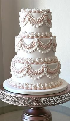 a three tiered white wedding cake sitting on top of a table