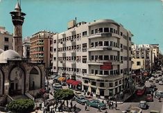 an old photo of a busy city street with cars and people on the road,