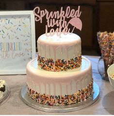 a birthday cake with sprinkles and a sign that says sprinkled with love