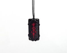 a black and red pendant hanging from a cord