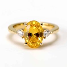 a yellow sapphire and diamond ring on a white background