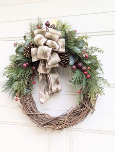 a christmas wreath with bells and evergreens hanging on a garage door in front of a white wall