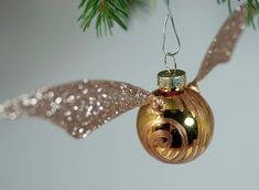 an ornament hanging from a christmas tree with glittery ribbon and bow on it