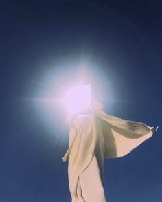 the sun shines brightly in the blue sky above a white cloth draped over a snowboarder