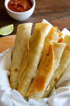 some tacos are in a white bowl on a table