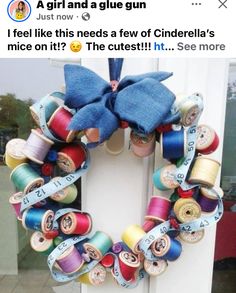 a wreath made out of spools of thread with a blue bow on it