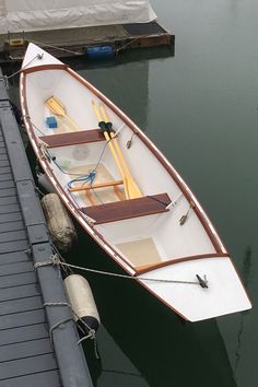 a small white boat tied to a dock