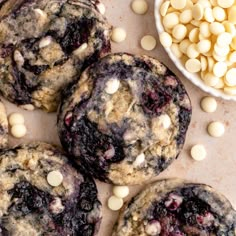 blueberry white chocolate chip cookies on a table next to a bowl of candy beans