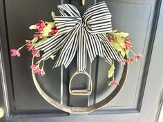 a wreath with flowers and a pair of scissors hanging from it's front door