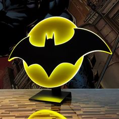 the batman symbol is lit up on a table