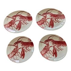 four red and white plates with lobsters on them