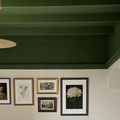 a bedroom with green walls and pictures on the wall