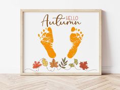 a wooden frame with an autumn hand and foot print in the center on a wood floor