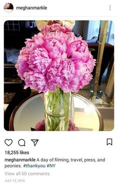 a vase filled with pink flowers sitting on top of a table next to a mirror