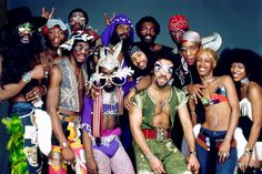 a group of men and women in costumes posing for a photo with one man wearing a mask