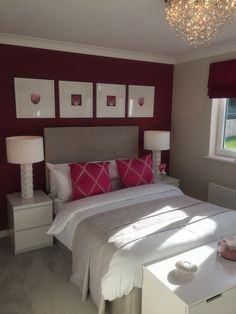 a bedroom with red walls and white furniture