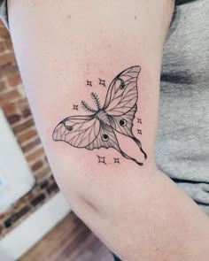 a woman's arm with a butterfly tattoo on the left side of her body