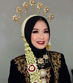 a woman wearing a head piece with flowers and pearls on it's head is smiling at the camera