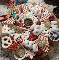 a wooden platter filled with lots of candy and cookies on top of a table