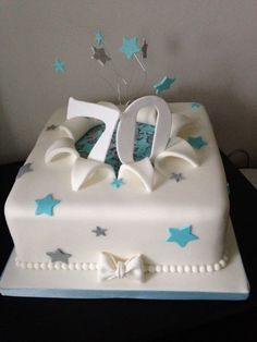 a white cake with blue and silver stars on it's side that has the number 20 on top