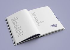 an open book on a purple surface with the pages folded in two different directions,