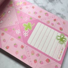 a close up of a piece of pink paper with strawberrys and stripes on it