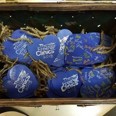 a bunch of blue tennis balls in a wooden box with string wrapped around the edges