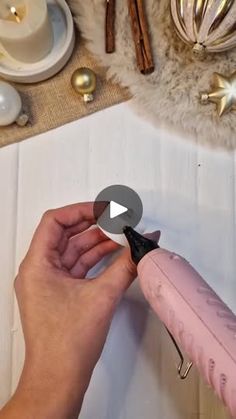 a person is cutting something with a pink handled shears on top of a table