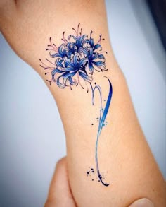 a blue flower tattoo on the wrist